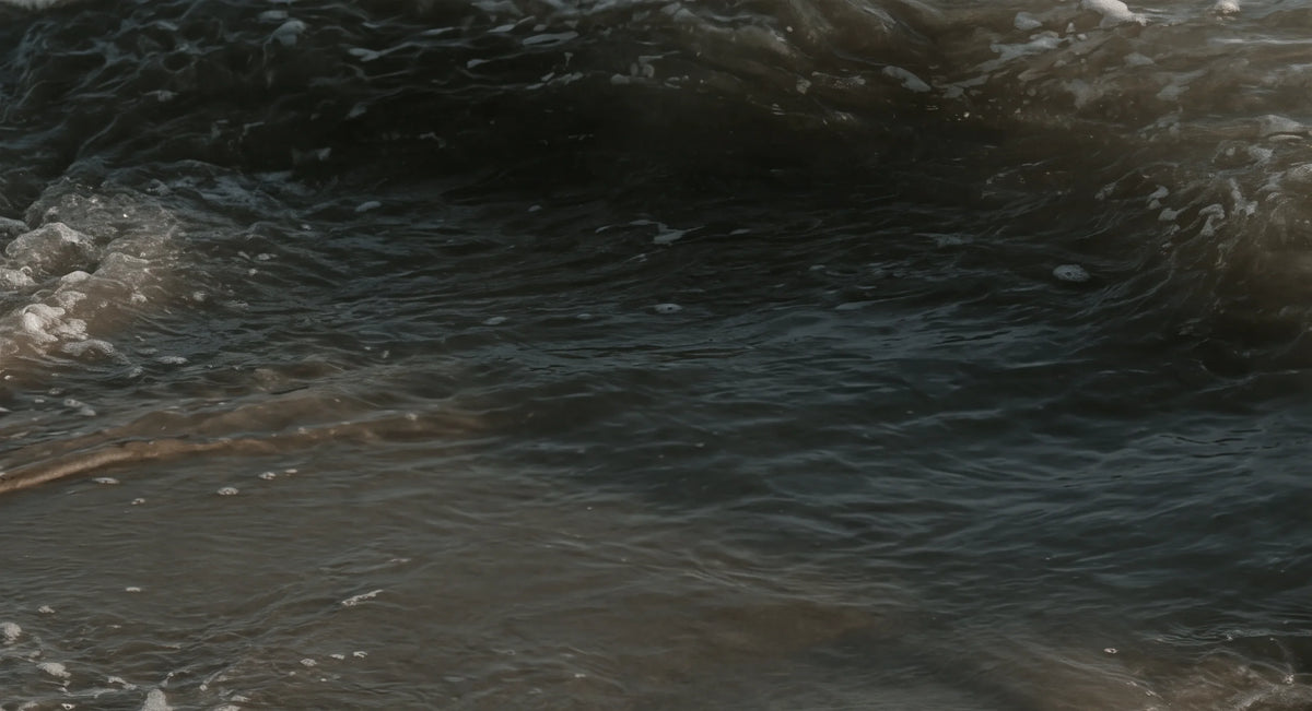 Close-up of dark ocean water with soft reflections and gentle waves.