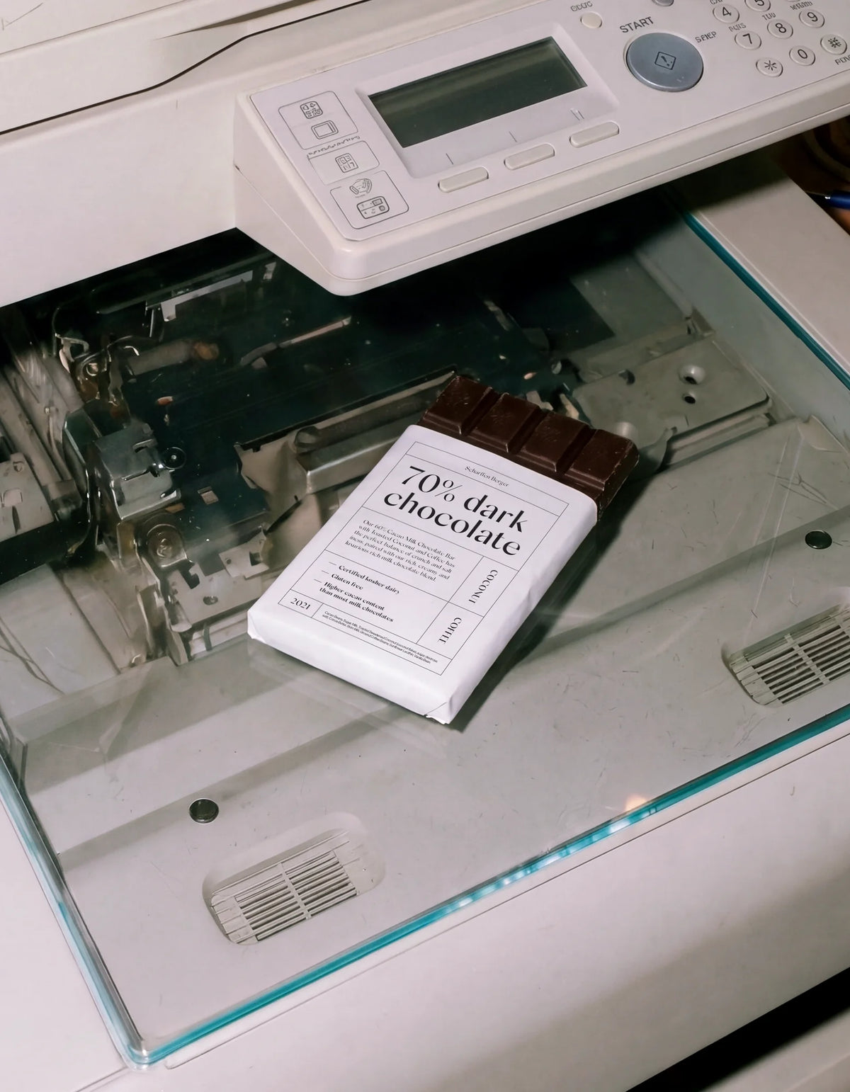 Dark chocolate bar packaging using Silk Sans typography, photographed on the glass of a photocopier.