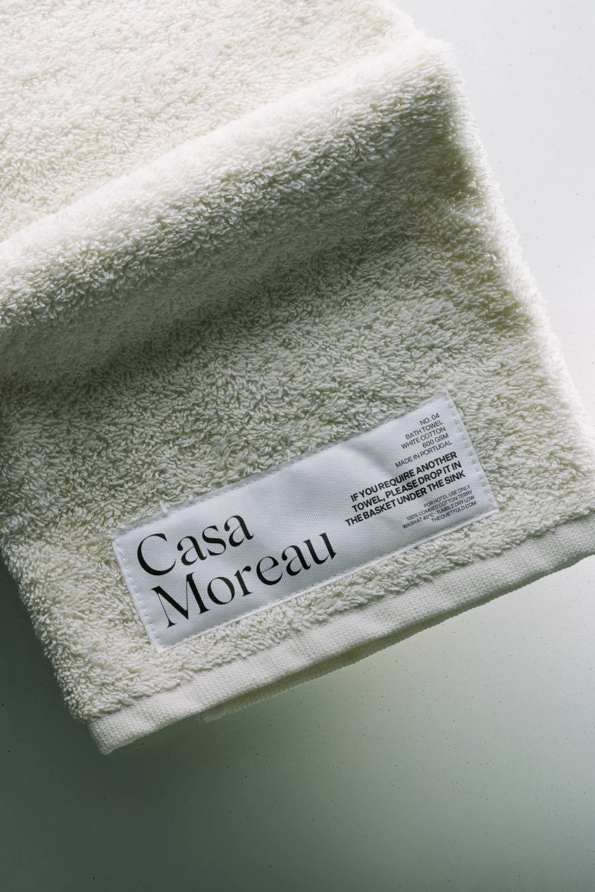 Silk Serif font used on a woven bath towel label with refined serif branding.