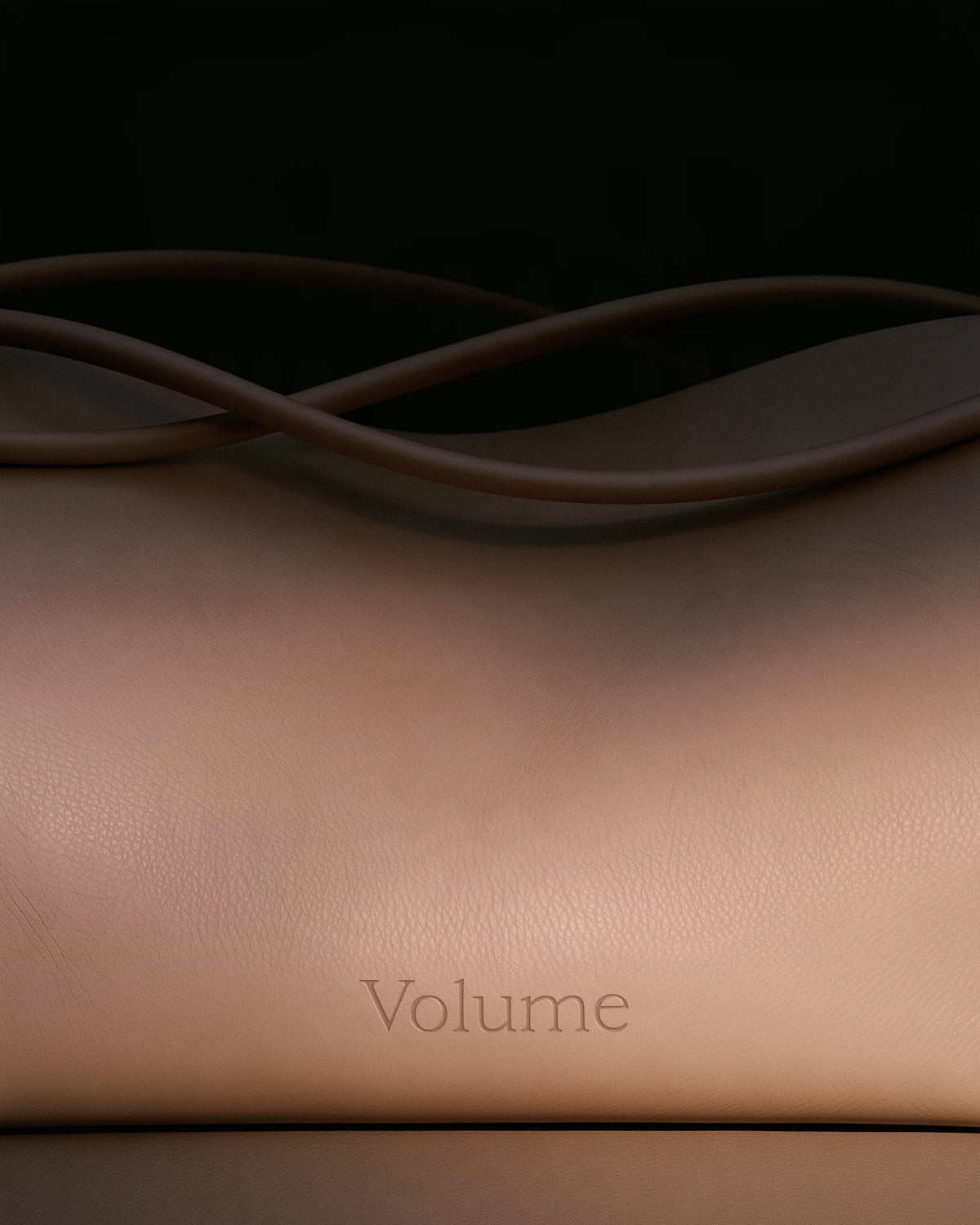 Close-up of a minimal beige leather object embossed with the word “Volume” in Velour Raw typography.