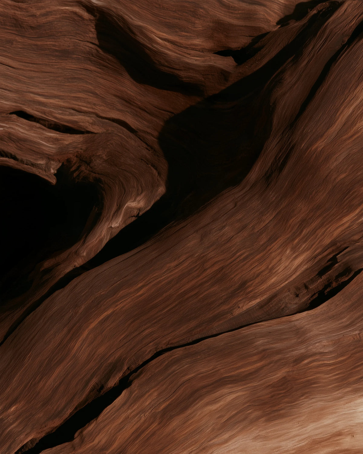 Close-up of dark weathered wood with flowing natural grain and warm brown tones, used as a visual background for Velour Raw.